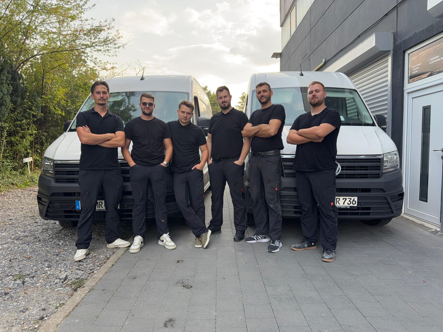 Team von Infinity Solutions vor den Servicefahrzeugen